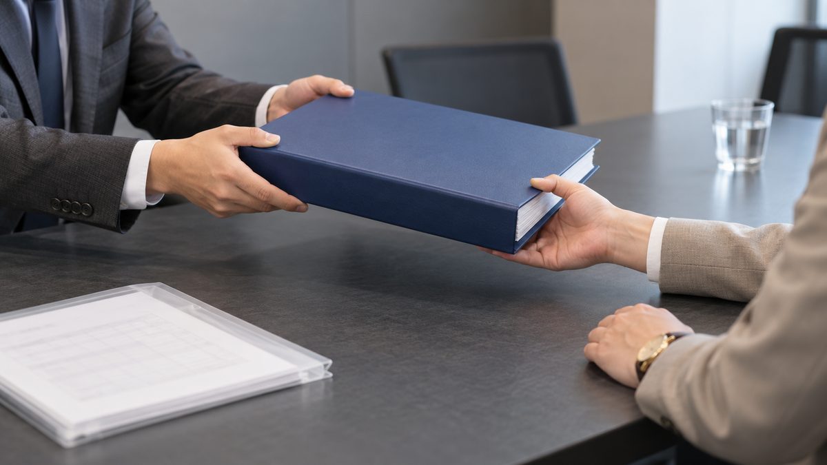 委託先から社内の担当者へ手順書のファイルを手渡す
