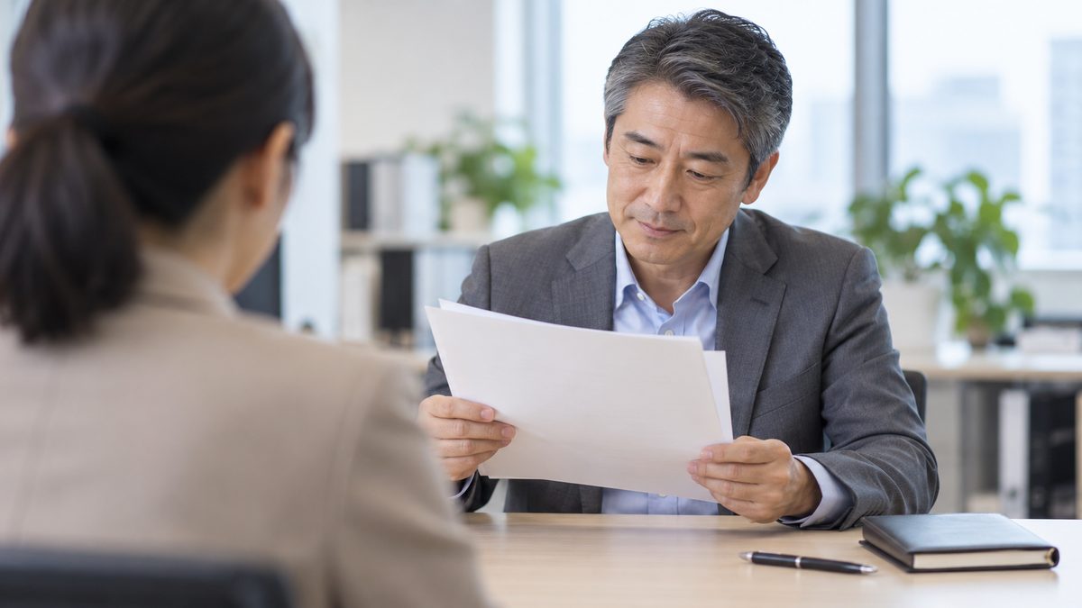 総務の担当者の肩越しに開発部の課長が規程の条文の案を両手で持って読む